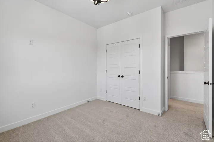 Carpeted room featuring white walls, white trim, and a ceiling-mounted light fixture