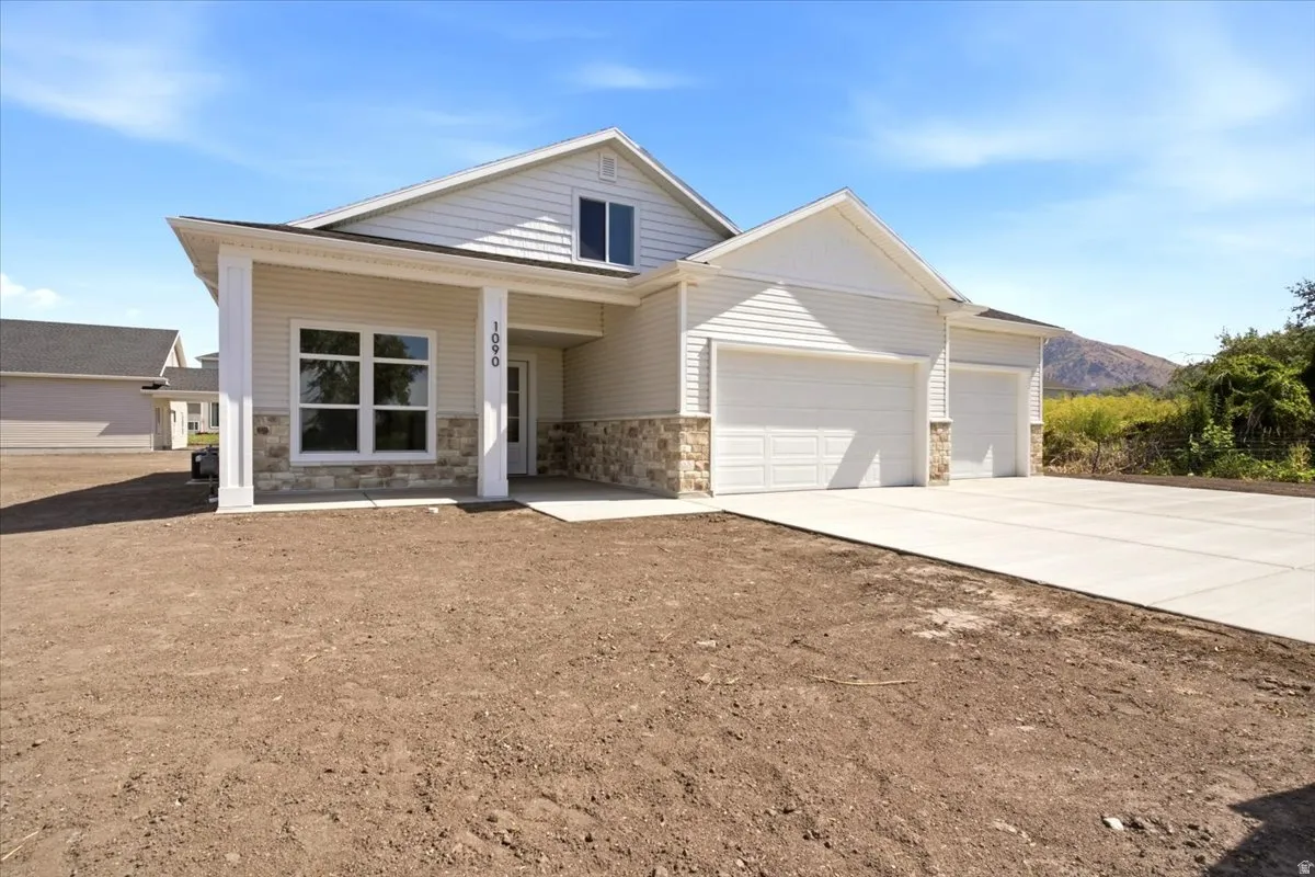 Contemporary-style residence featuring light-toned siding and stone veneer accents