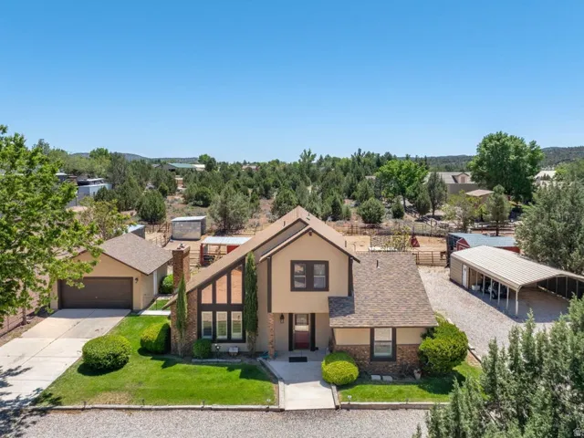 Two-story stucco and brick-veneer residence featuring a prominent architectural chimney accent