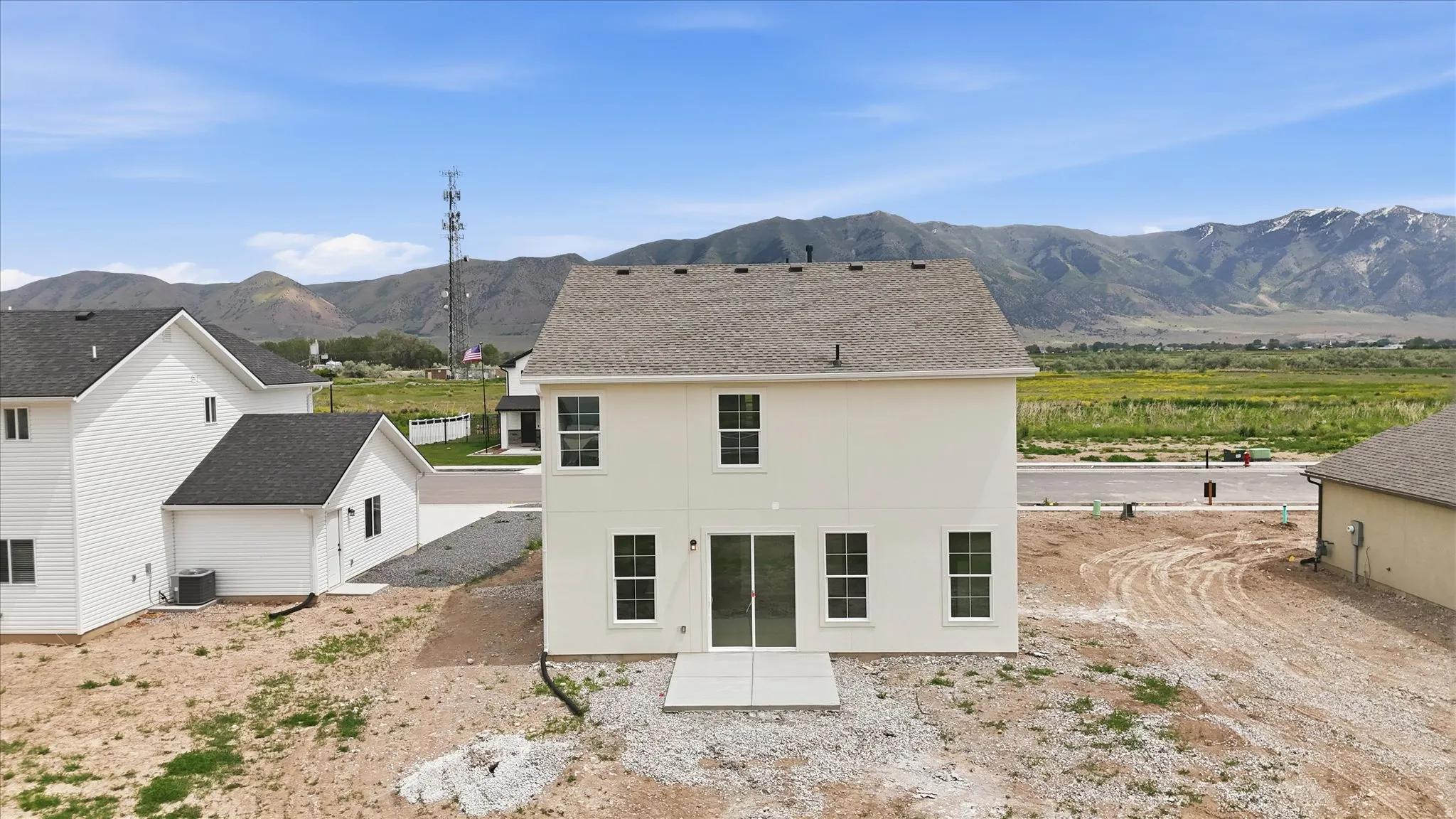 Contemporary two-story residence featuring a neutral exterior, a private patio, and a shingled roof