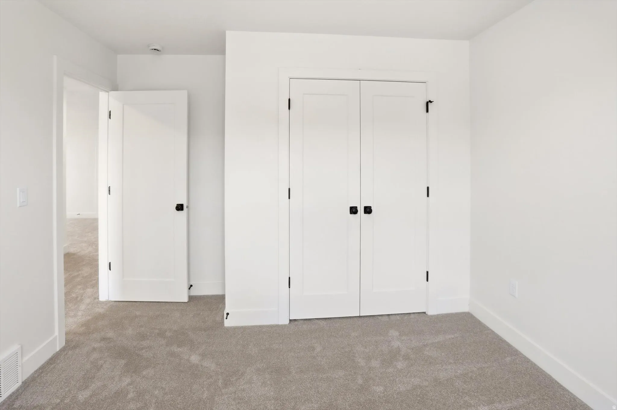 Neutral-toned carpet flooring complements the white walls and trim