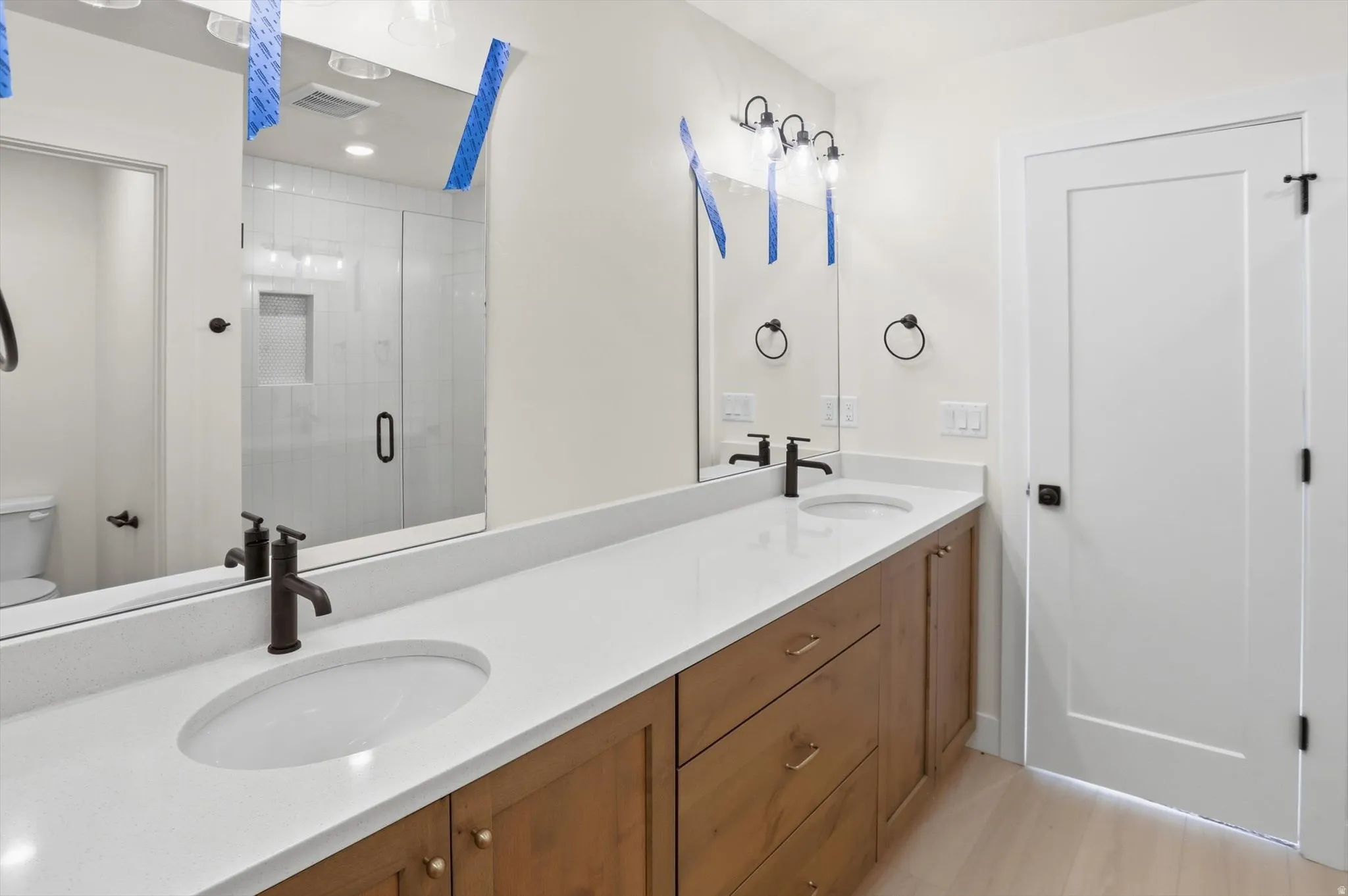 Dual vanity with white undermount sinks, quartz countertops, and matte black fixtures