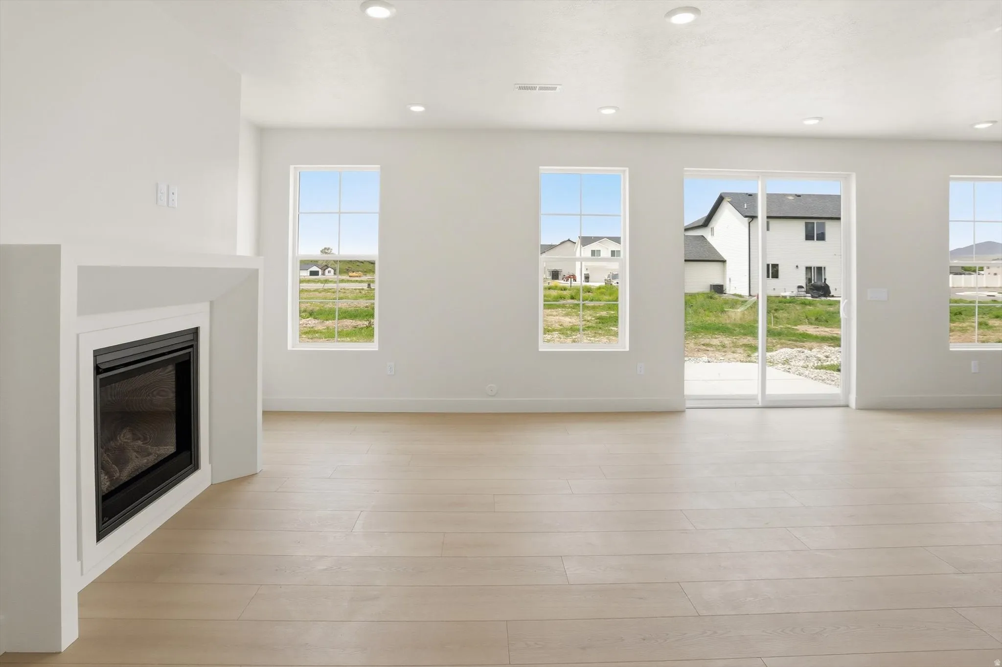 Bright interior featuring light wood-finish flooring and recessed lighting