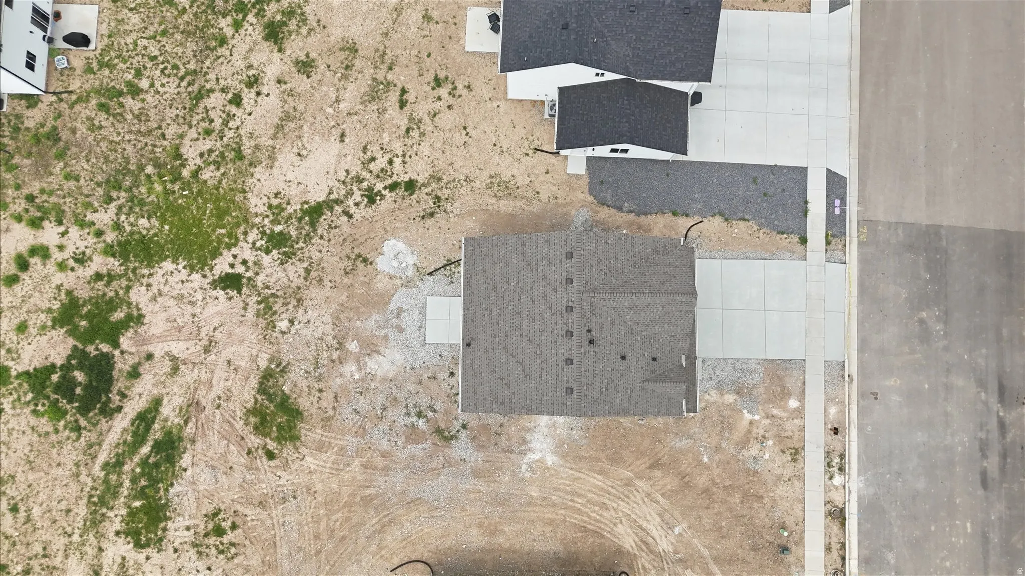 New construction home featuring a dark shingle roof and a concrete driveway