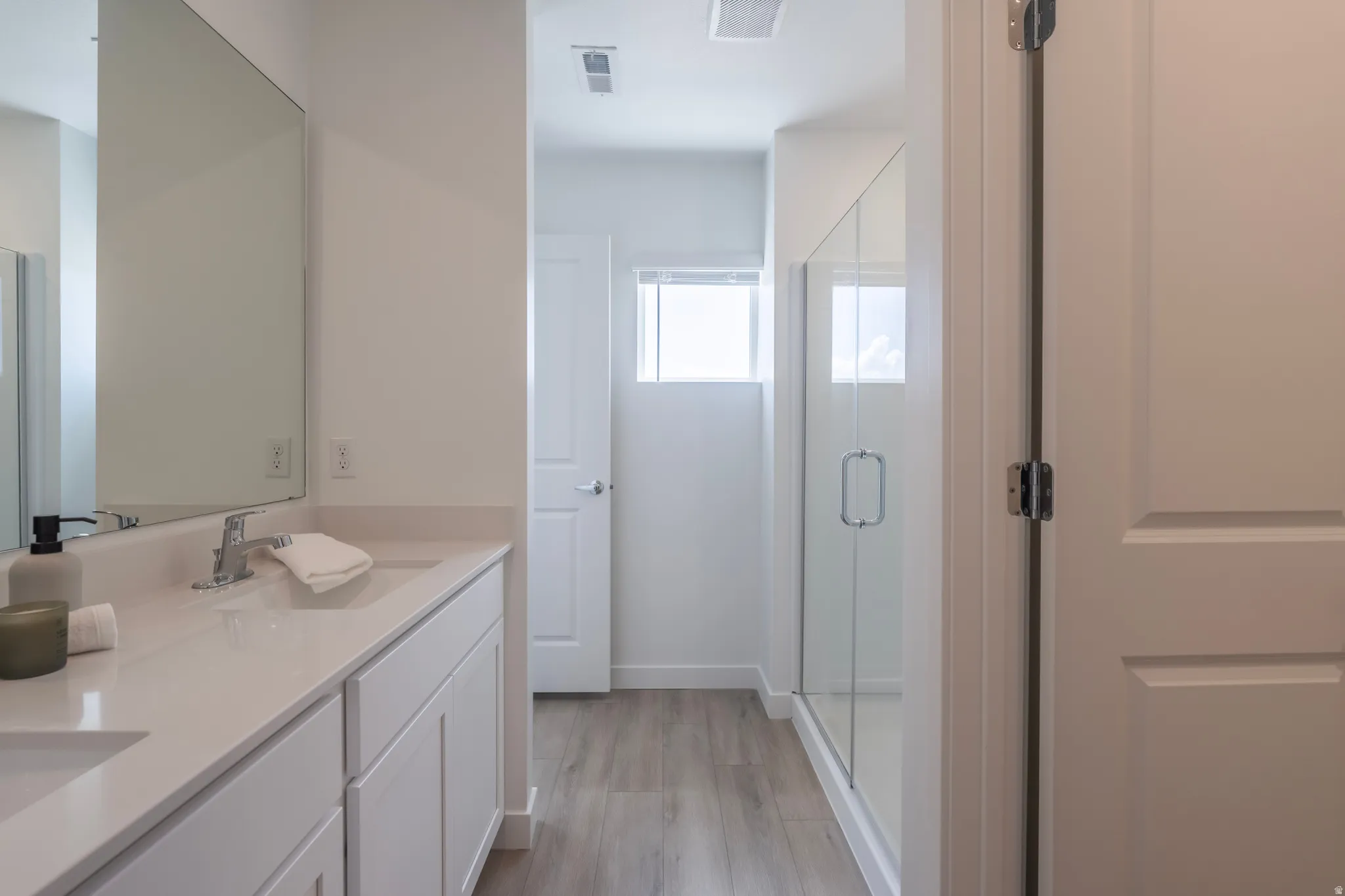 Dual vanity with light-toned countertop, rectangular undermount sinks, and chrome fixtures