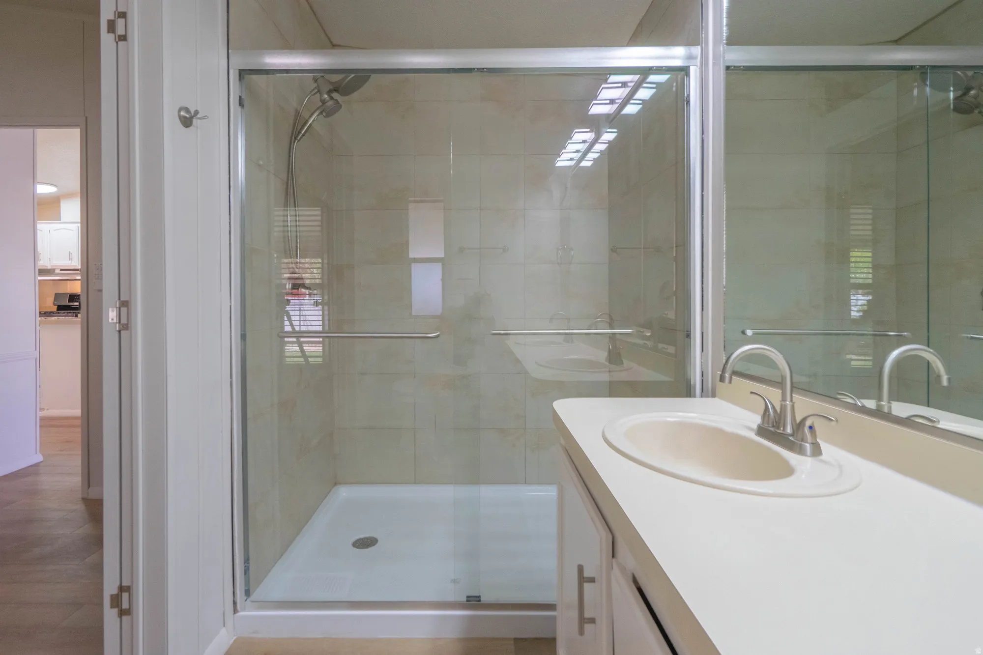 Contemporary bathroom featuring a walk-in shower with clear glass enclosure and tiled walls