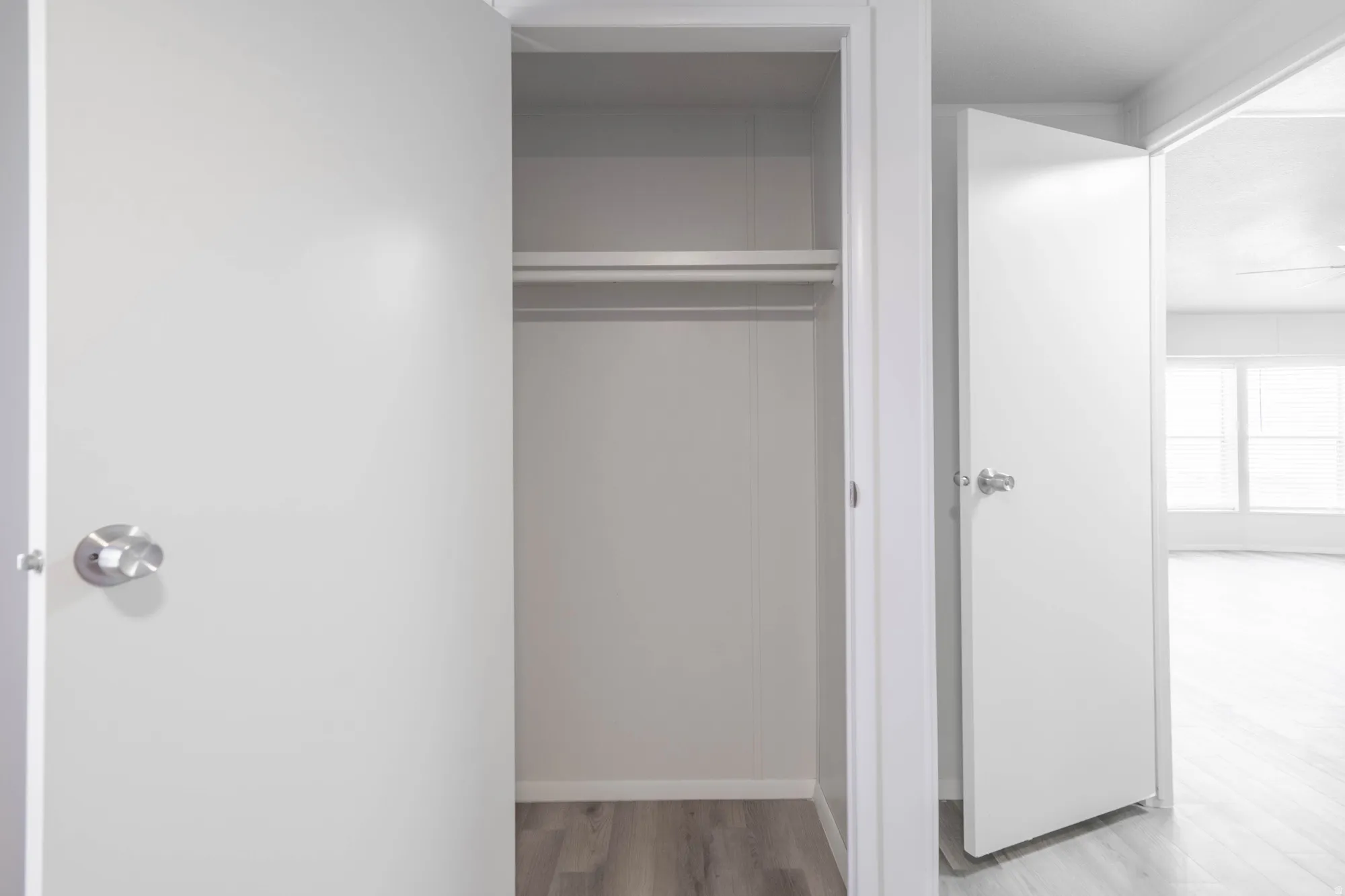 Interior closet featuring a clothes rod and wood-finish flooring