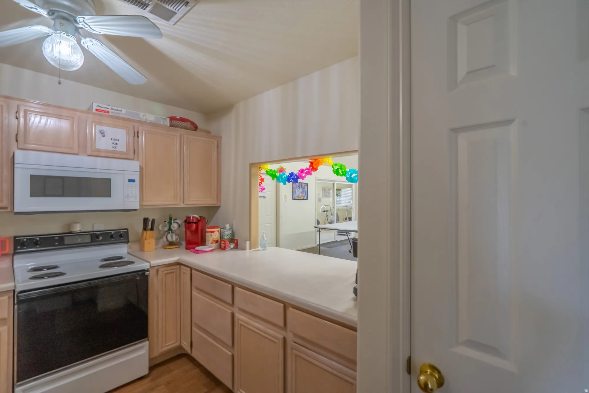Kitchen featuring wood-finish cabinetry, solid surface countertops, and a white oven with an overhead microwave