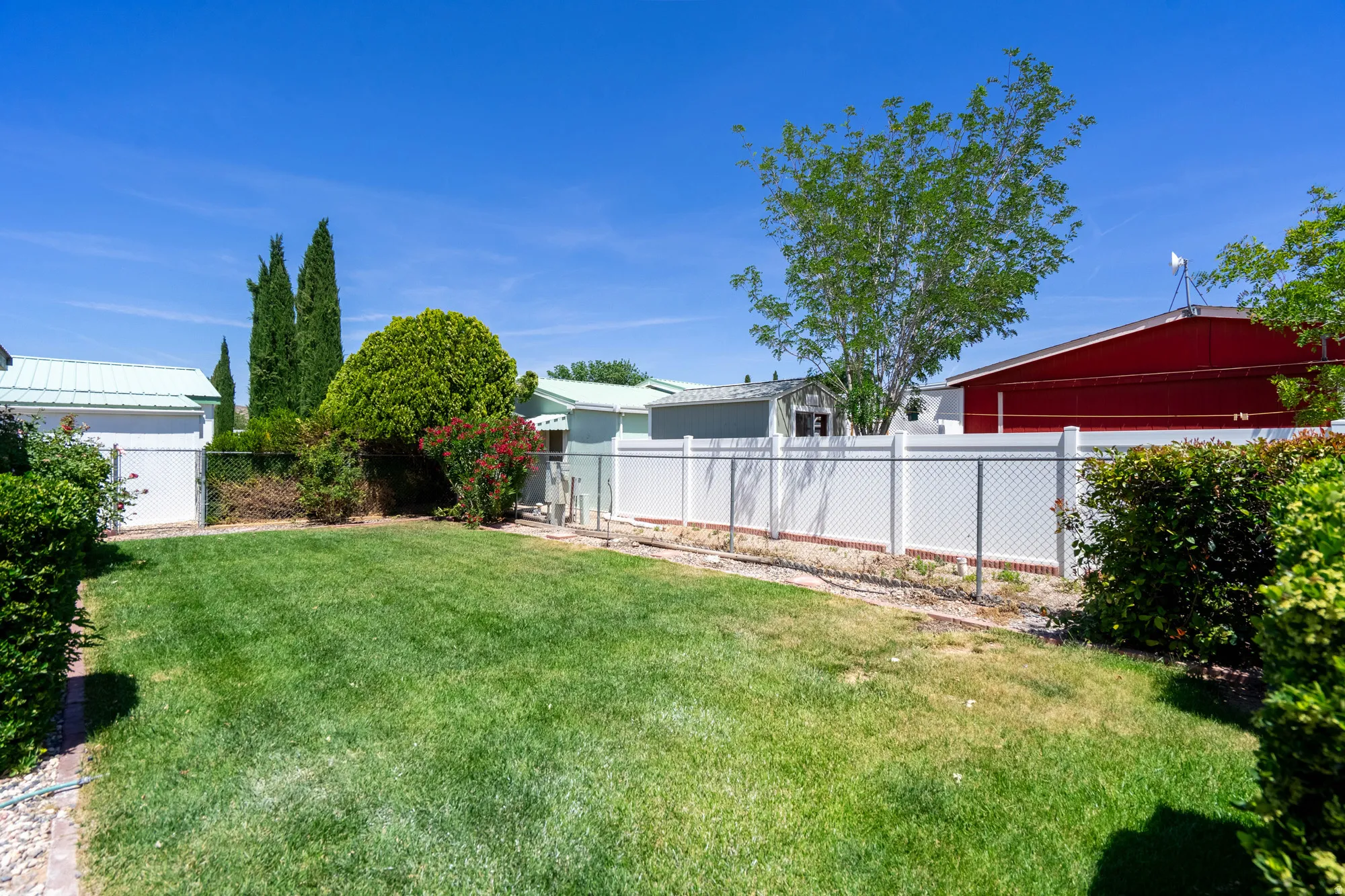 Expansive green lawn area featuring mature trees and shrubs
