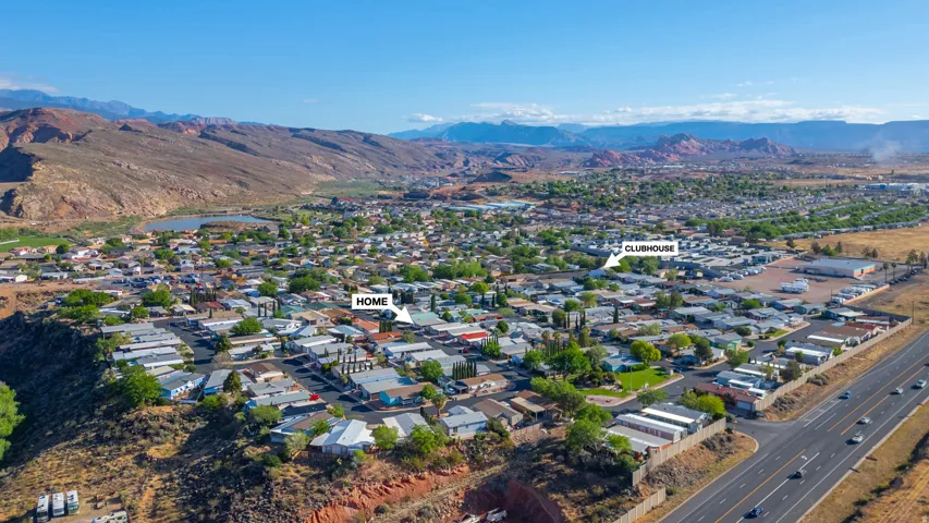 Aerial overview of a residential community with surrounding topographical features and a visible highway