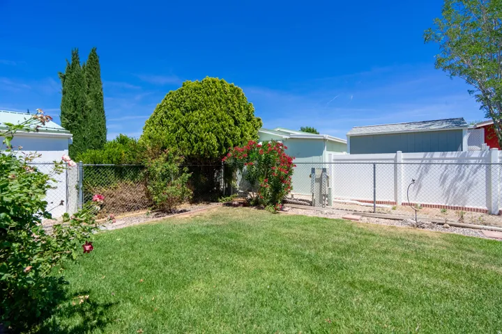 Expansive grassy yard area featuring chain link fencing and a partial privacy fence