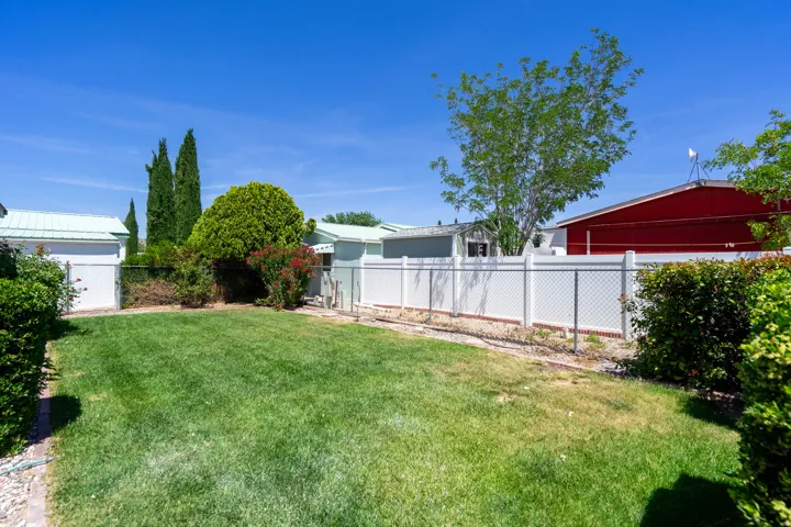 Expansive green lawn area featuring mature trees and shrubs