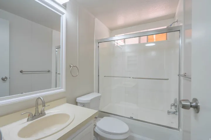 Bathroom featuring a vanity with a drop-in sink and a framed mirror