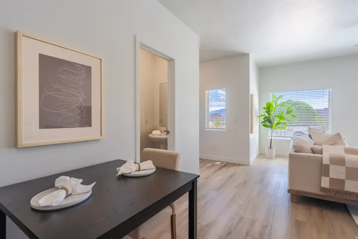 Open concept living space featuring wood-finish flooring, white walls, and multiple windows