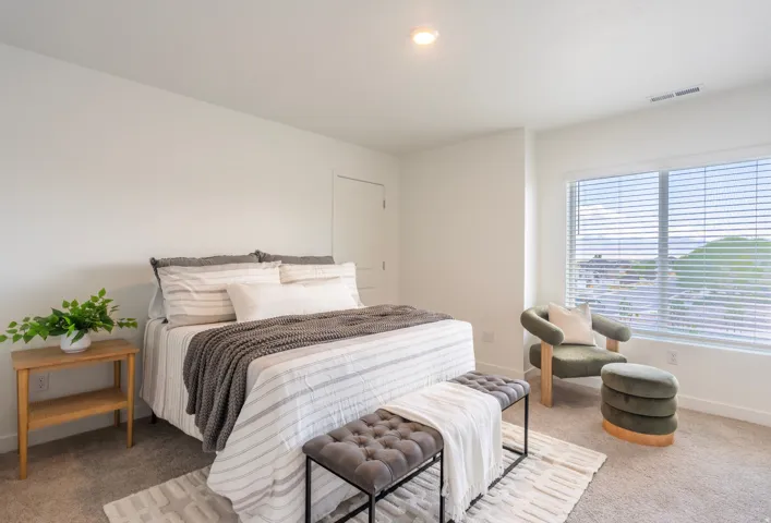 Recessed ceiling lighting, large window with blinds, light-toned carpeting, and white walls