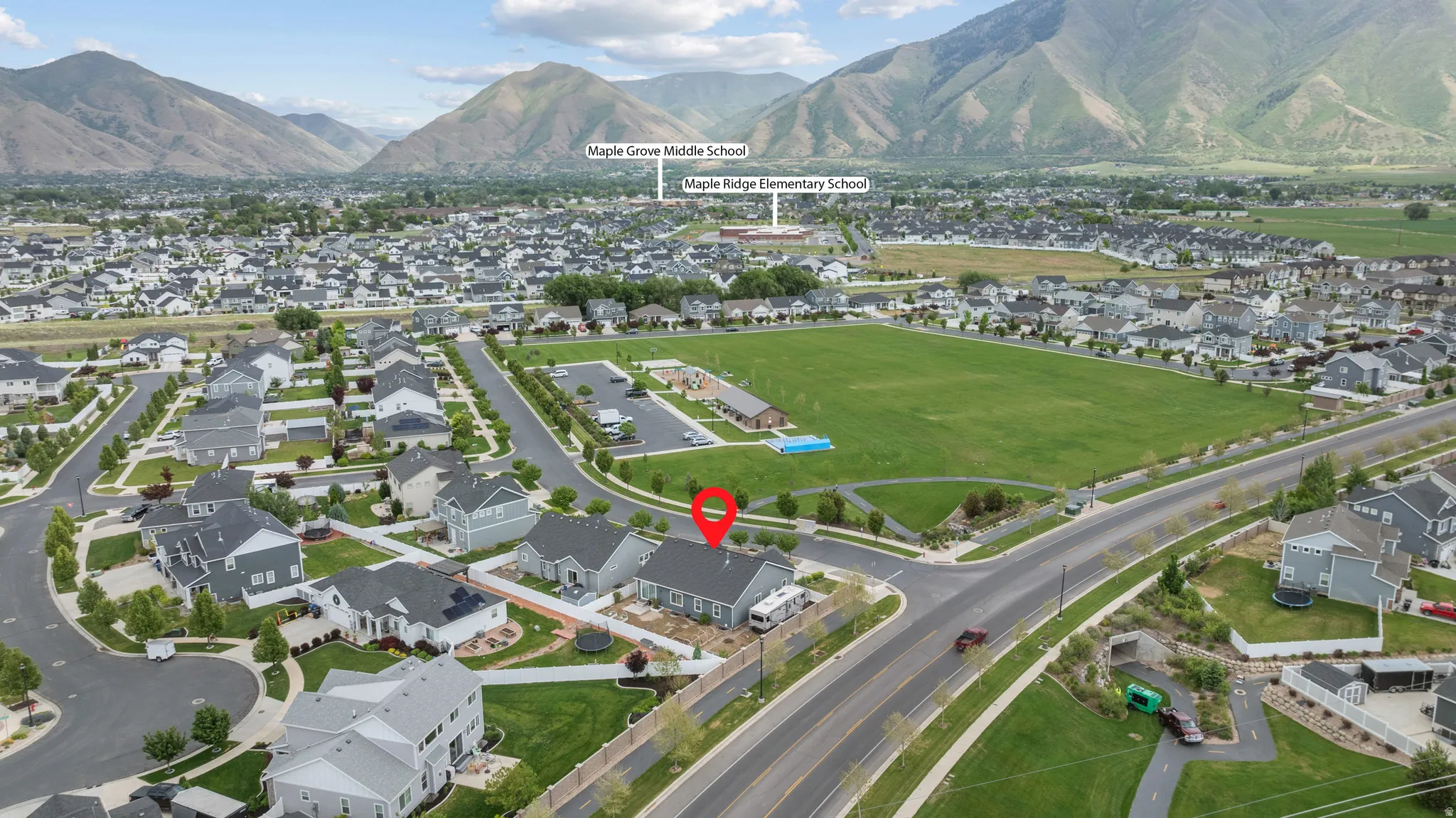 Aerial perspective of a developed residential neighborhood featuring a central green space