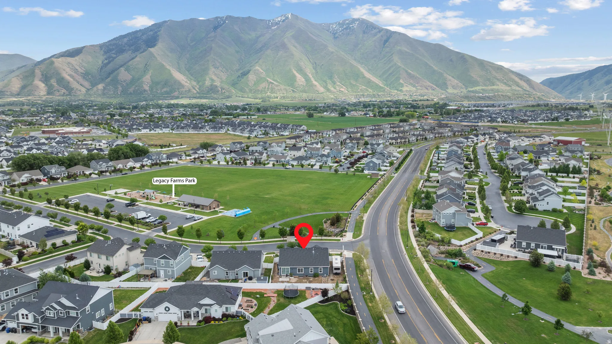 Aerial perspective showcasing the lovely residential neighborhood with mountain backdrop and spacious park