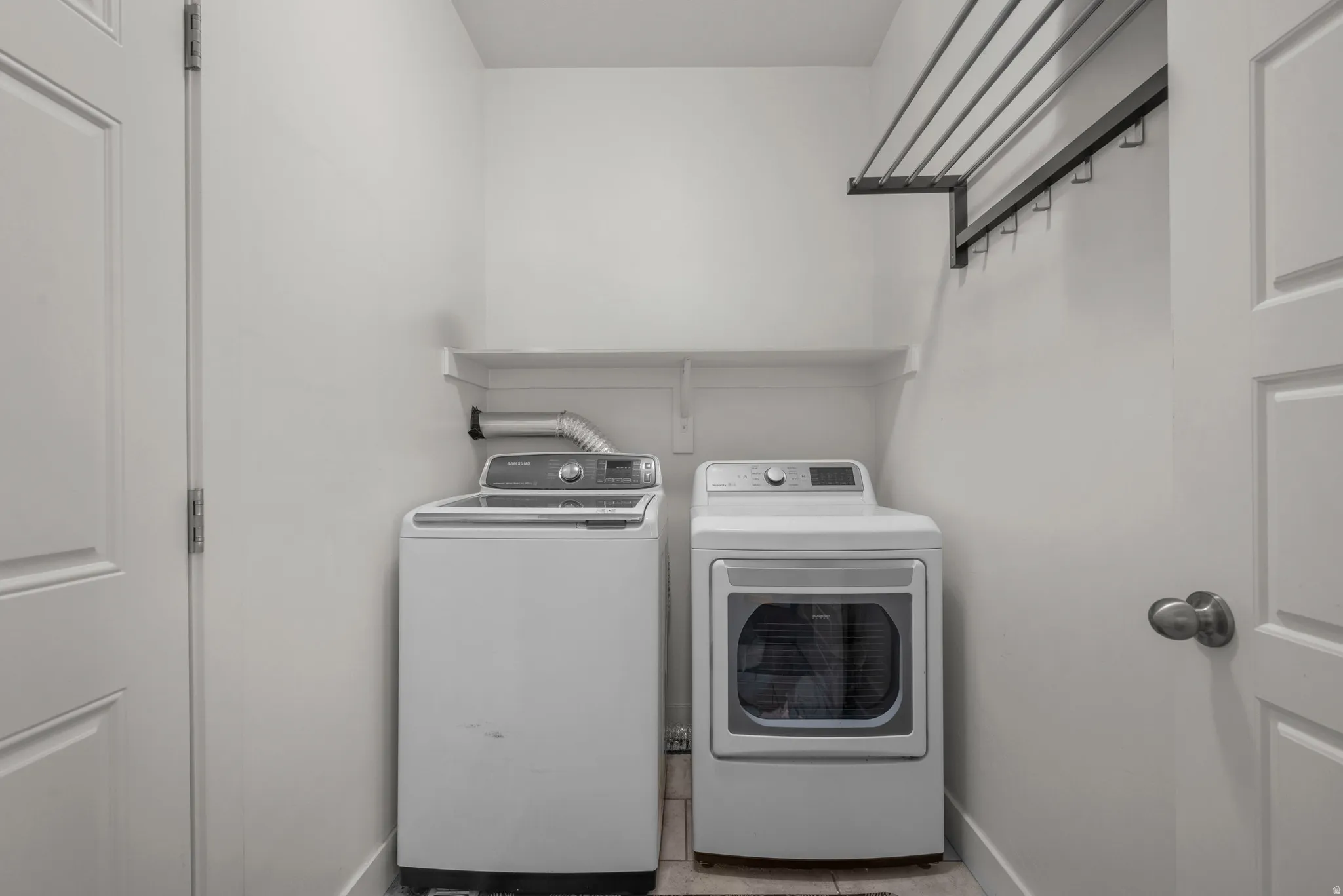 Dedicated laundry room with doors featuring shelving.