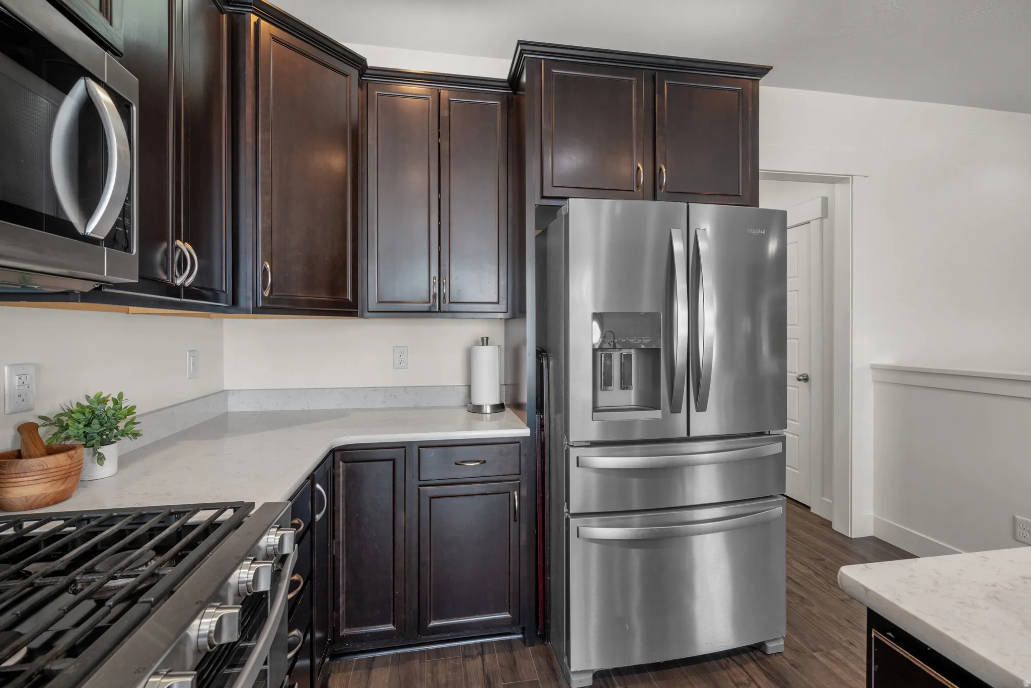 Kitchen featuring upgraded dark wood-finish cabinetry with self closing drawers, and light-toned quartz countertop