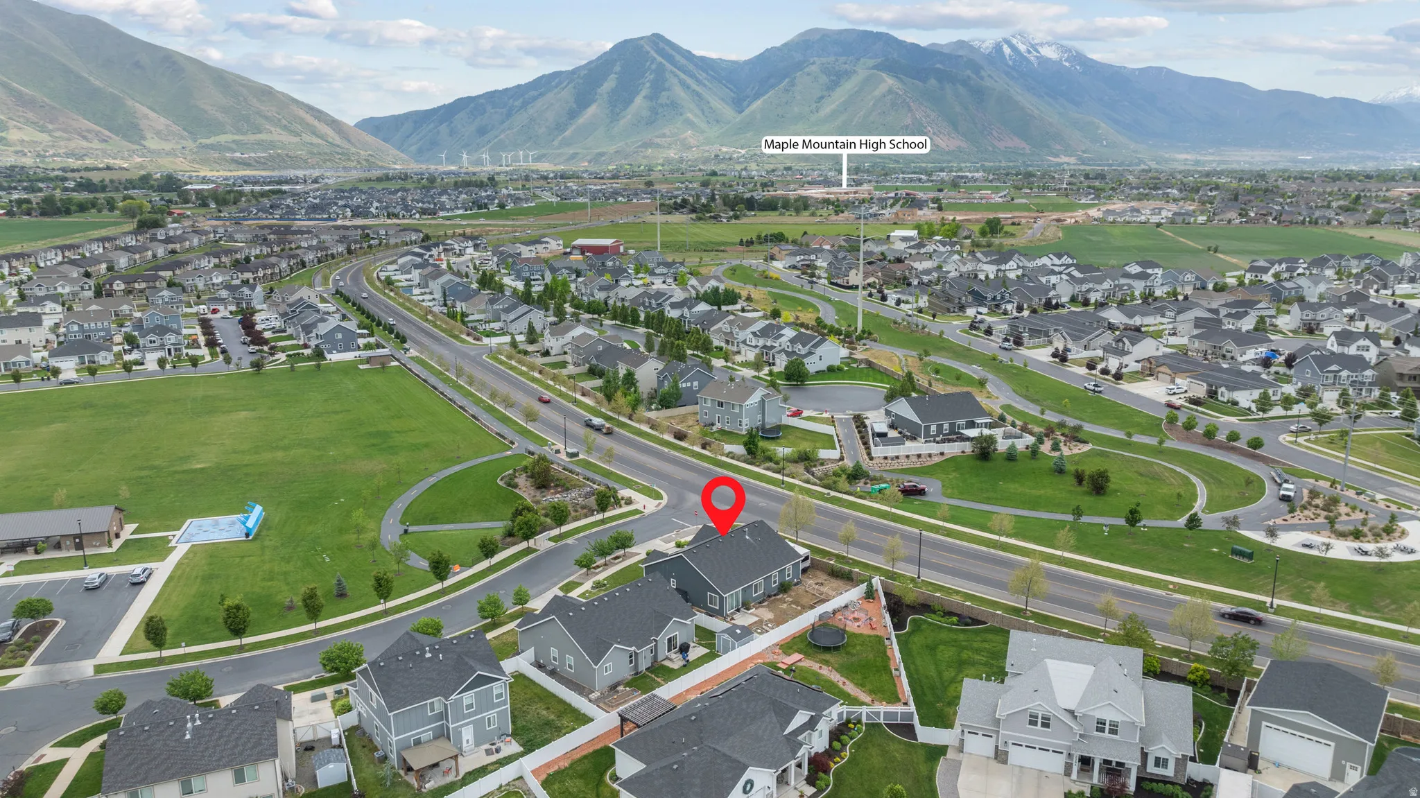 Aerial perspective showcasing a residential community with contemporary homes, mountain backdrop, and green spaces