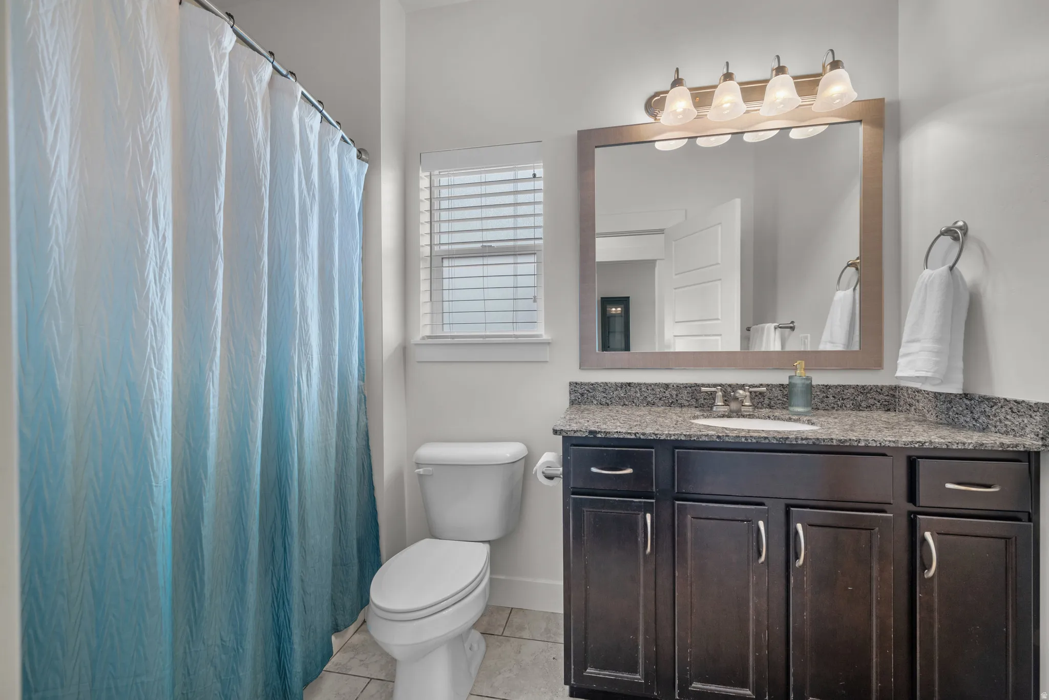 Full Bathroom tub/shower combination featuring a dark wood vanity with a granite countertop