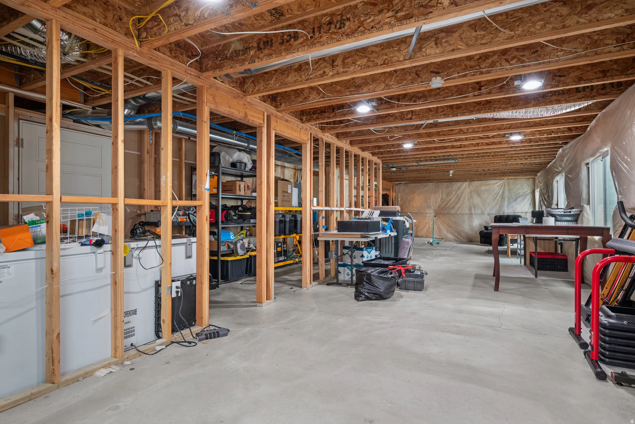 Unfinished basement featuring exposed wood framing, an open ceiling with visible joists, recessed lighting fixtures, and a concrete floor. This part of the basement could be made into two bedrooms. Not shown is other side which has potential for a 3rd bas