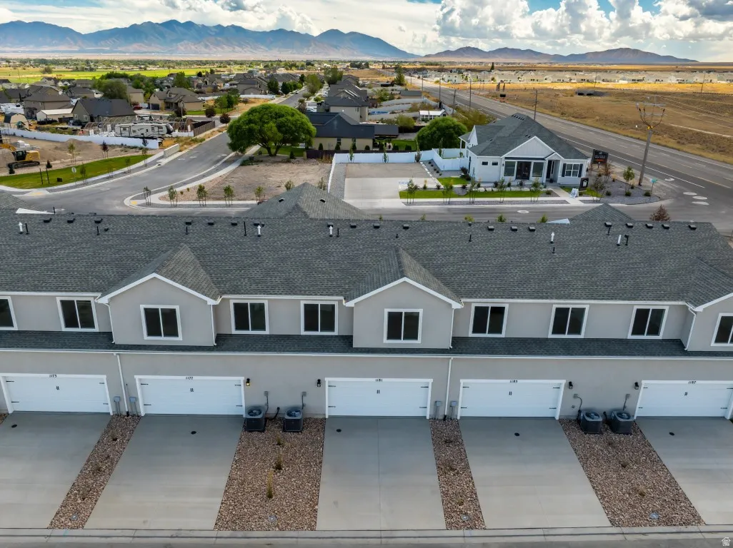 Modern townhome exterior with gray siding, attached garages, and a gravel landscape strip