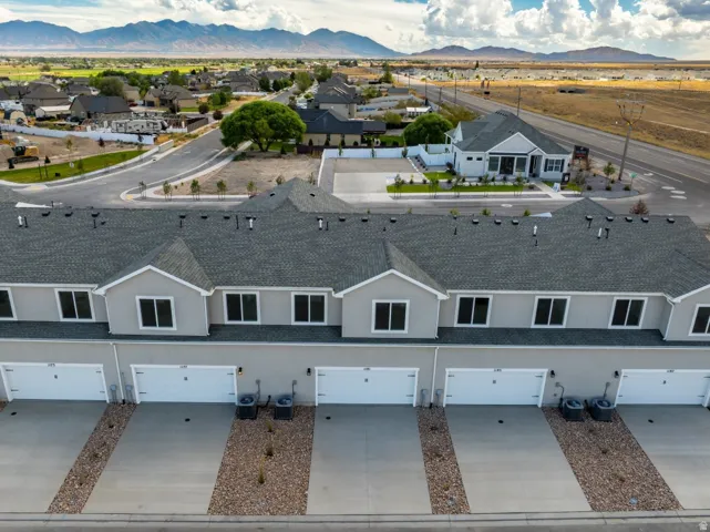 Modern townhome exterior with gray siding, attached garages, and a gravel landscape strip