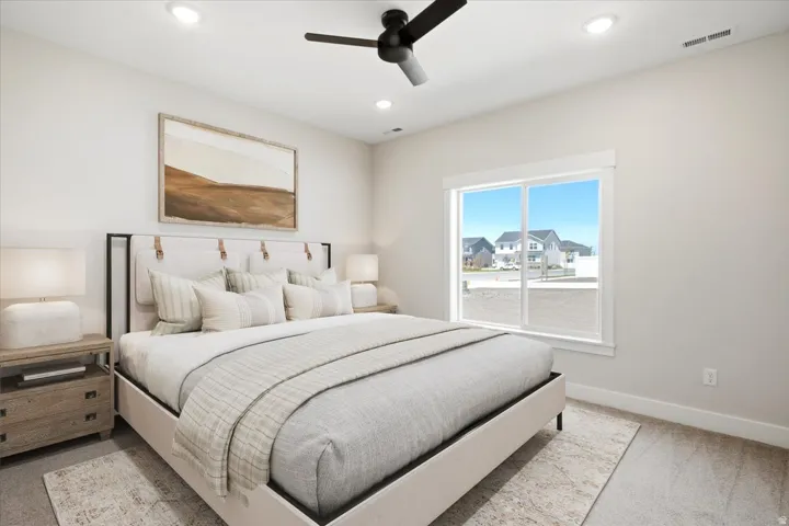 Bedroom featuring a ceiling fan with integrated lighting, recessed ceiling lights, a large window with white trim, light-colored walls, and wood-finish flooring