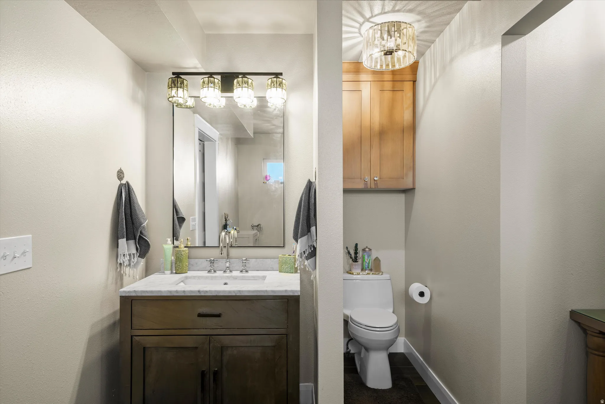 Powder room featuring a wood-finish vanity with a white countertop and rectangular undermount sink