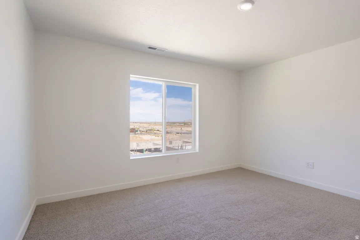 Recessed ceiling light, neutral wall paint, white window trim, and carpeted flooring