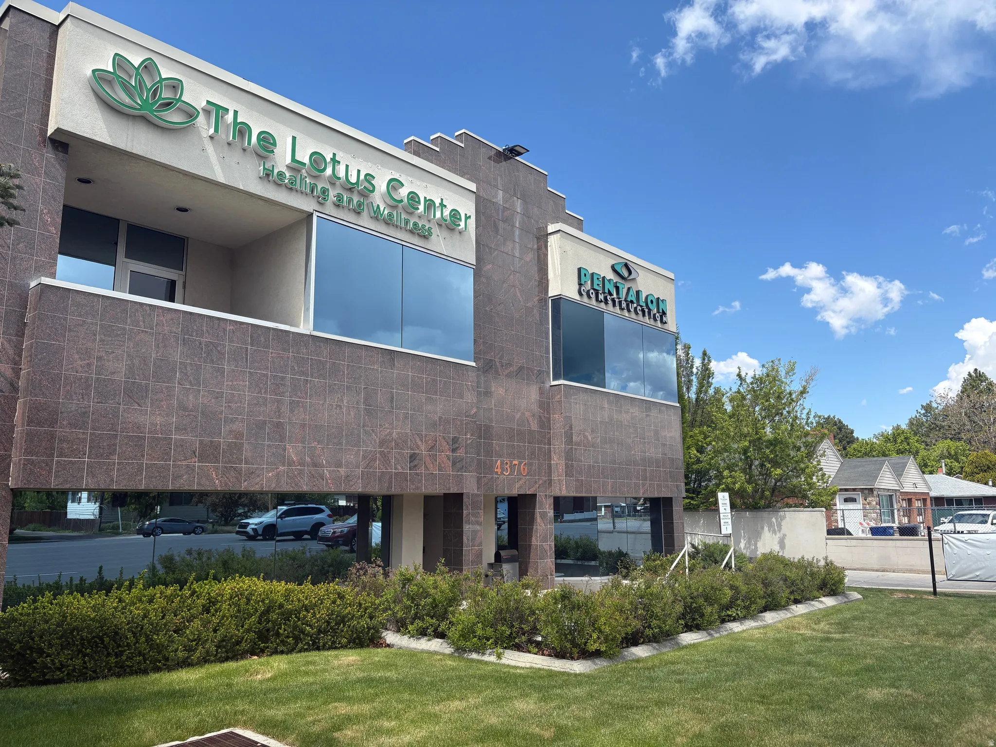Commercial building featuring a tiled exterior facade and expansive tinted windows
