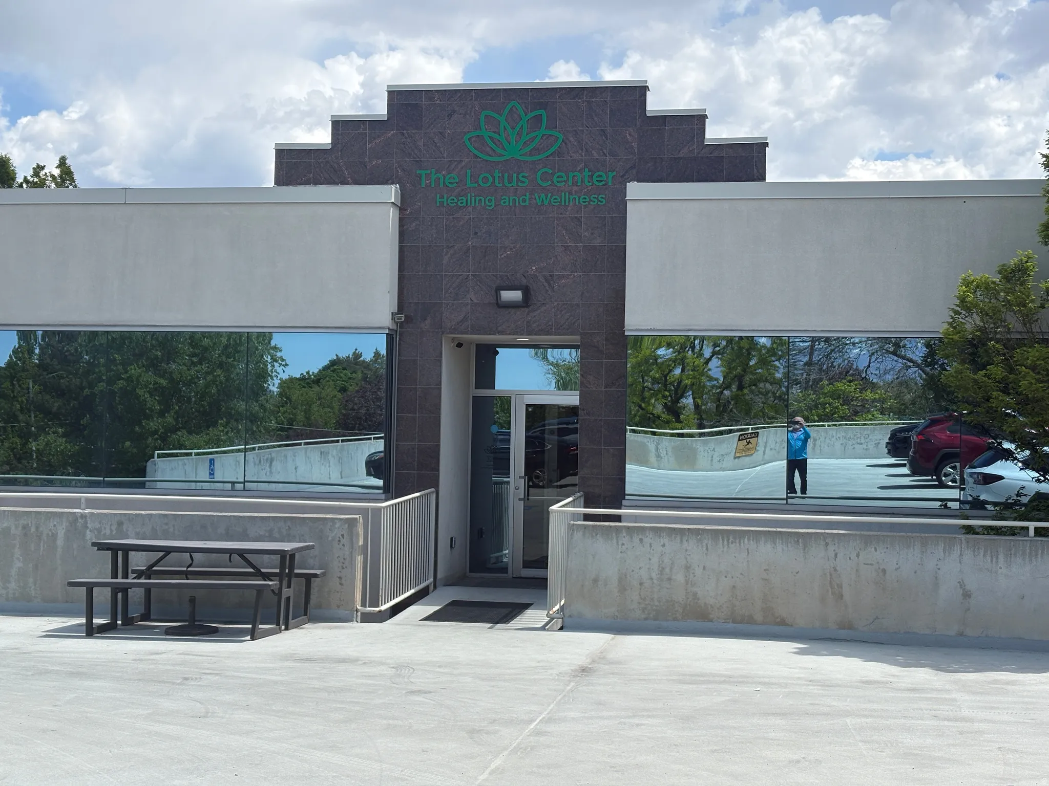 Commercial building exterior featuring a dark stone facade and reflective window panels