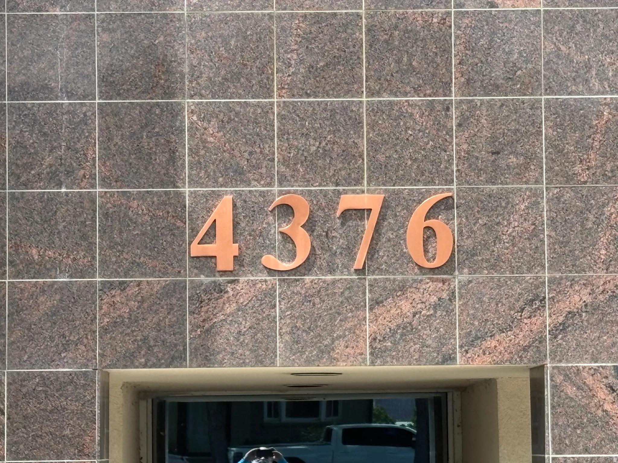 Building exterior featuring square-cut granite tile cladding with visible natural veining