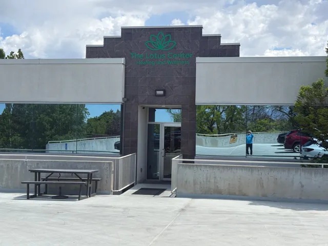Commercial building exterior featuring a dark stone facade and reflective window panels