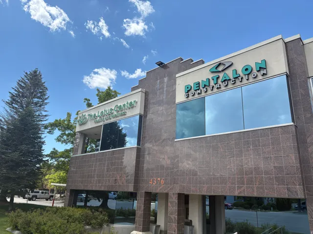 Multi-story commercial building featuring a stone-tile facade and large reflective windows