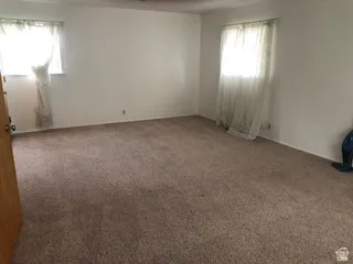 Spacious room featuring neutral carpeting and white wall finishes