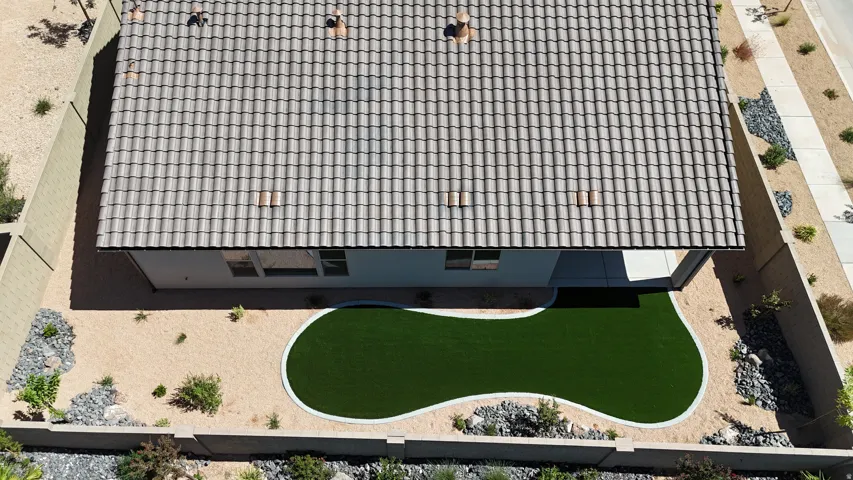 Tile roof with multiple vents, rear patio, artificial turf, and low-maintenance desert landscaping