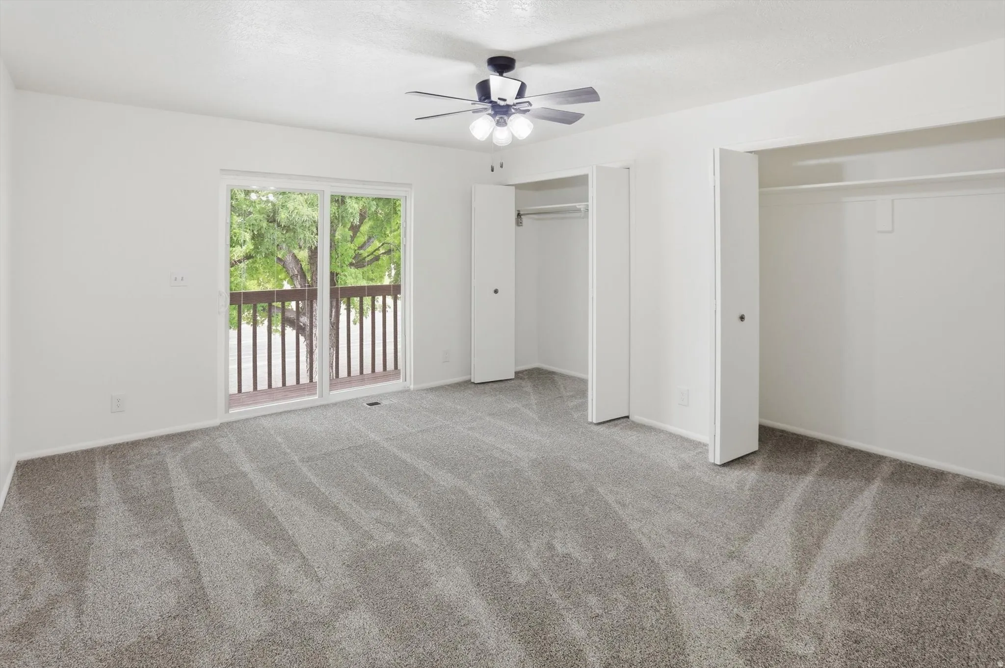 Spacious room featuring neutral carpeting and white walls