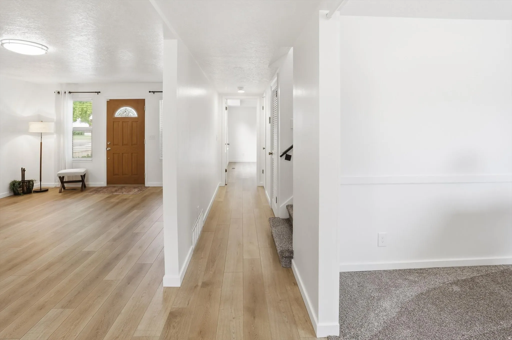 Light wood-finish flooring throughout, complemented by crisp white walls and white trim