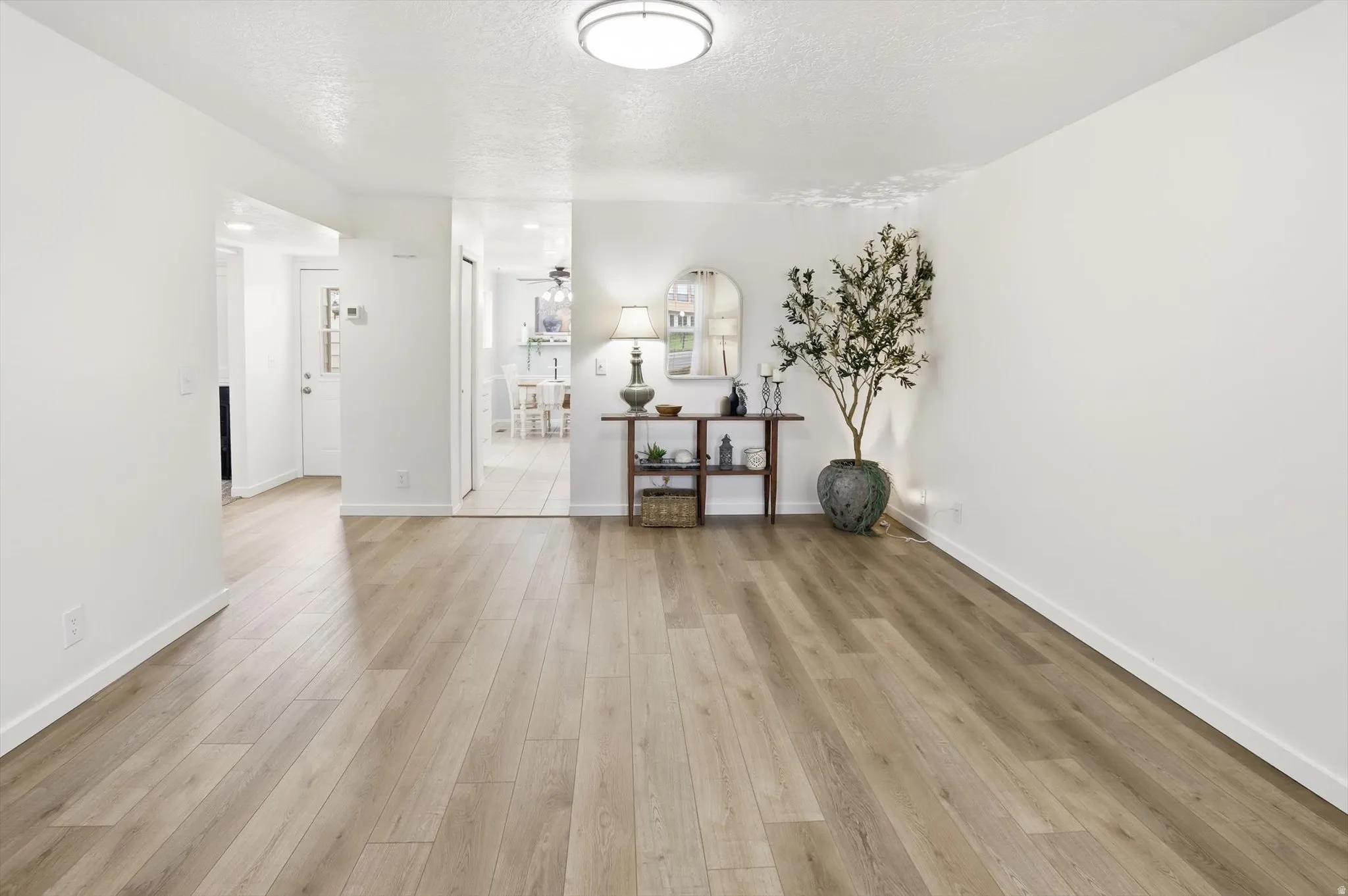 Spacious room featuring wood-finish flooring, white baseboards, and neutral wall paint