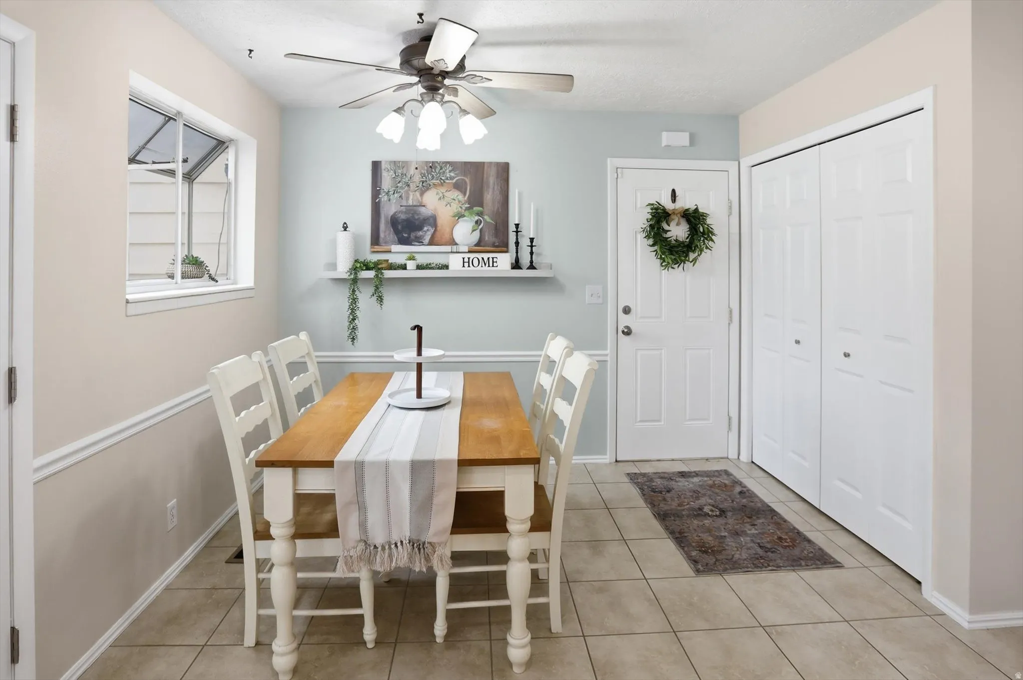 Dining area featuring a ceiling fan, a window, and tiled flooring