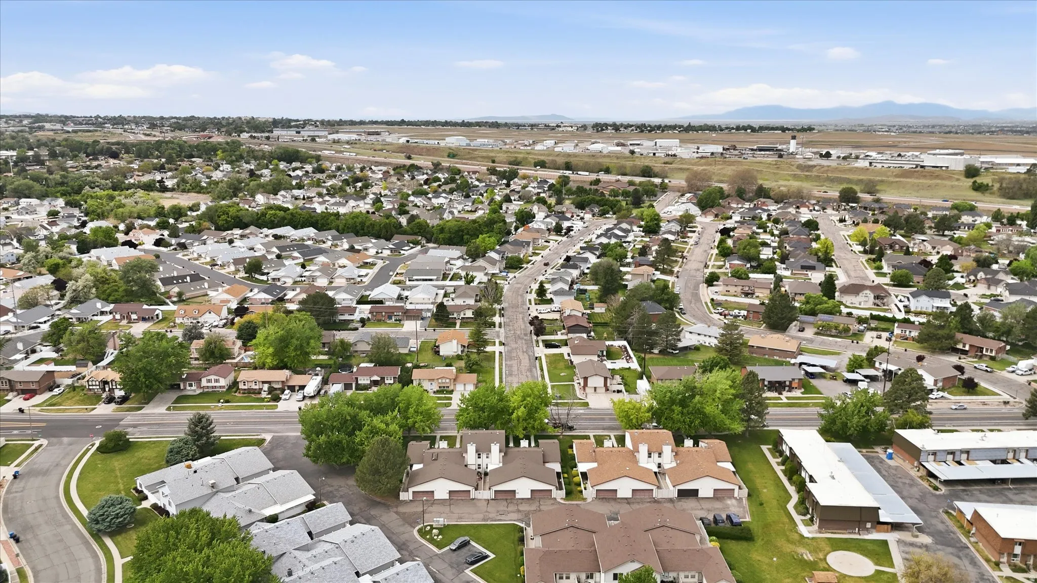 Expansive aerial perspective showcasing a residential neighborhood with a mix of single-family homes and multi-unit residences