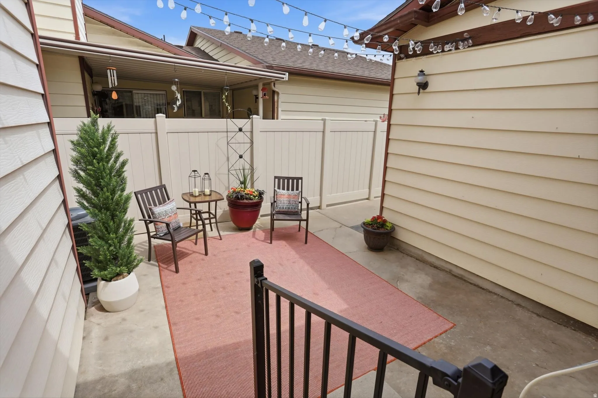 Concrete patio space featuring a privacy fence and exterior siding