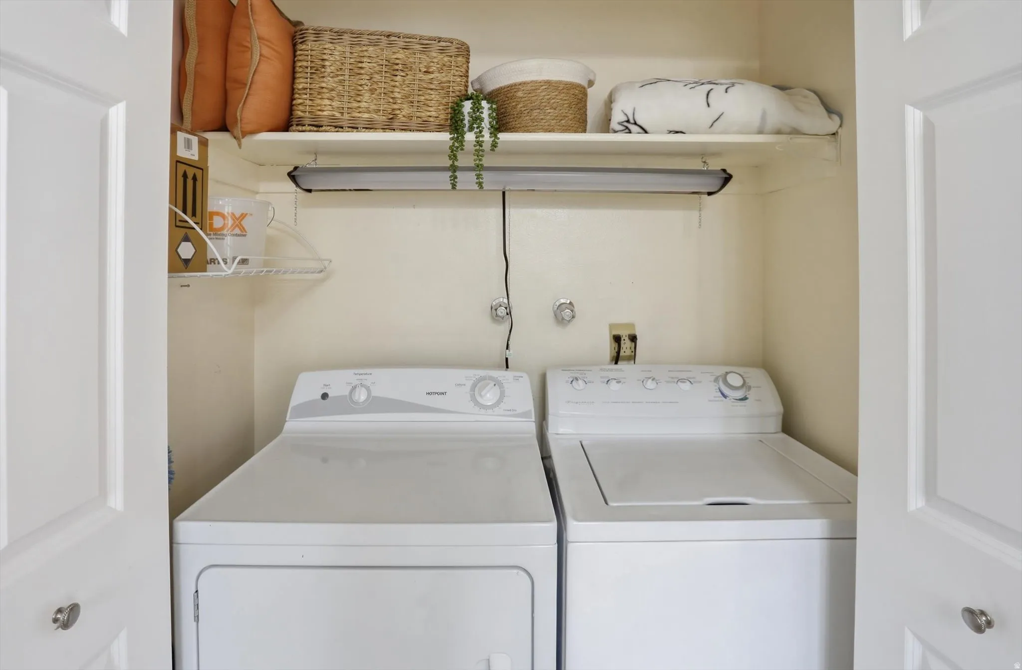 Dedicated laundry area featuring a white top-load washing machine and a white front-load dryer