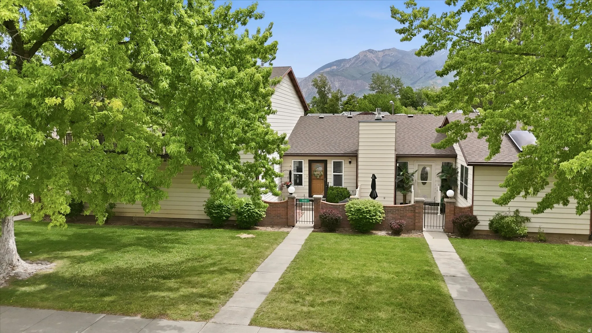 Duplex property featuring light-colored siding and a brown shingle roof