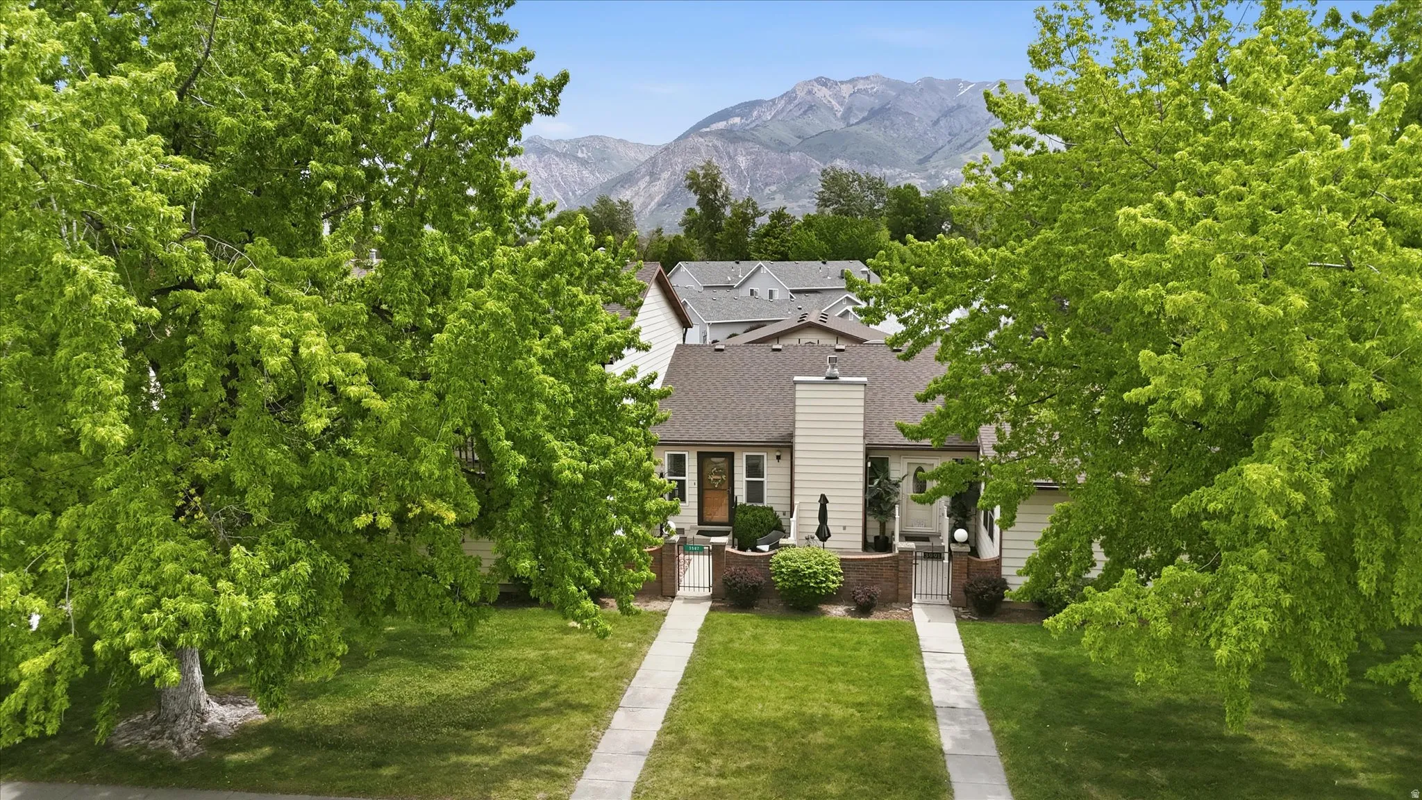 Exterior residence featuring a chimney, brown roof shingles, and light-colored siding