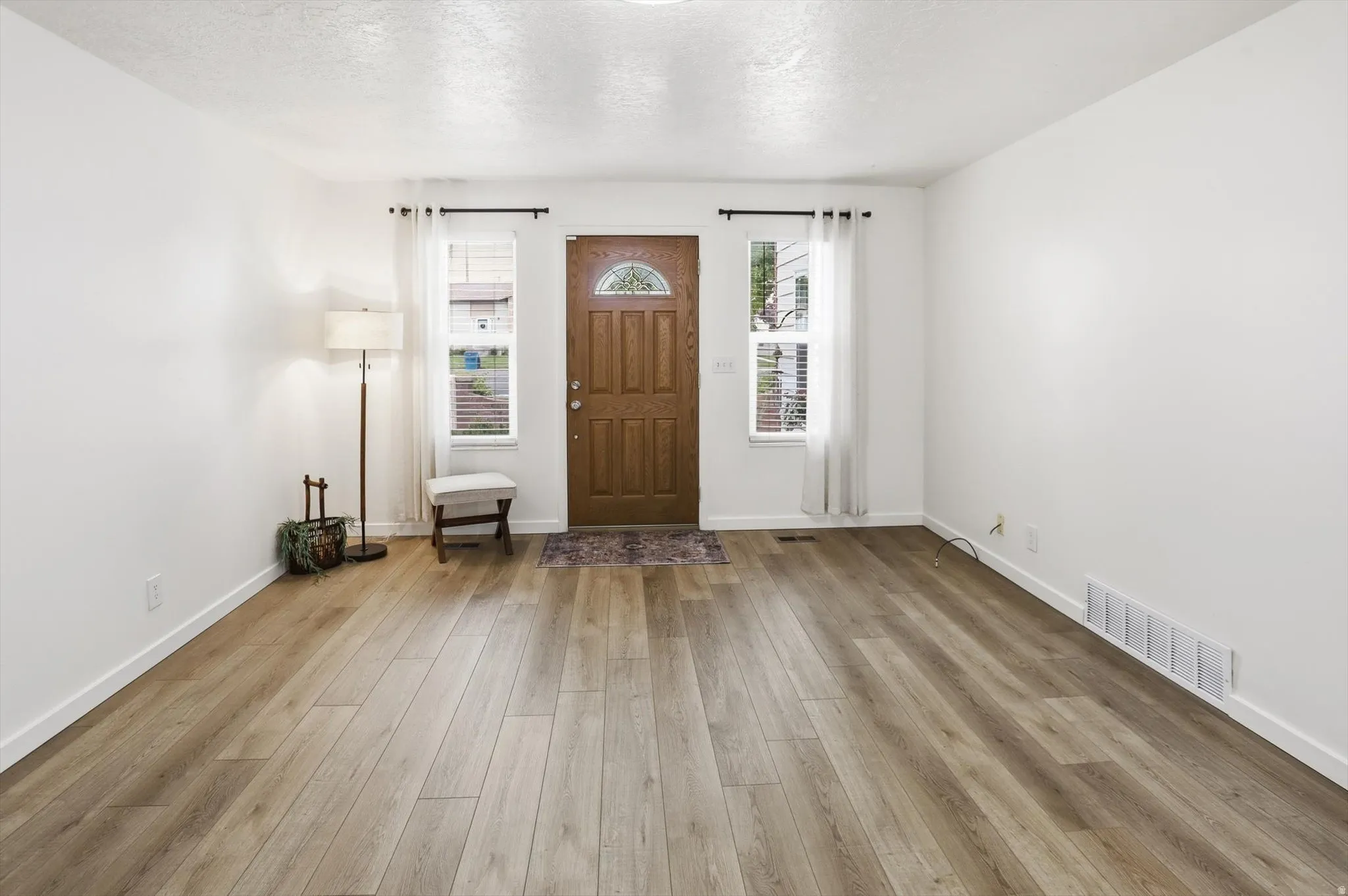Bright entryway featuring wood-finish flooring, white walls, and a recessed ceiling light