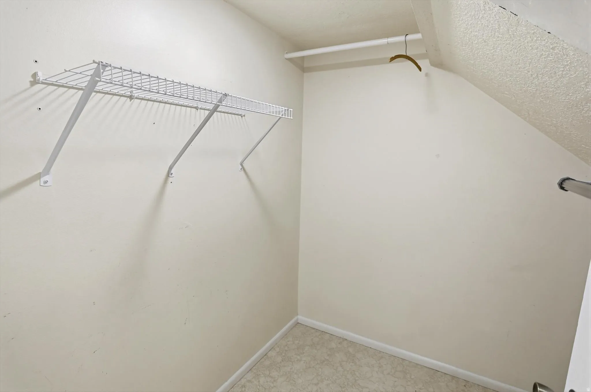 Walk-in closet with wire shelving and a hanging rod