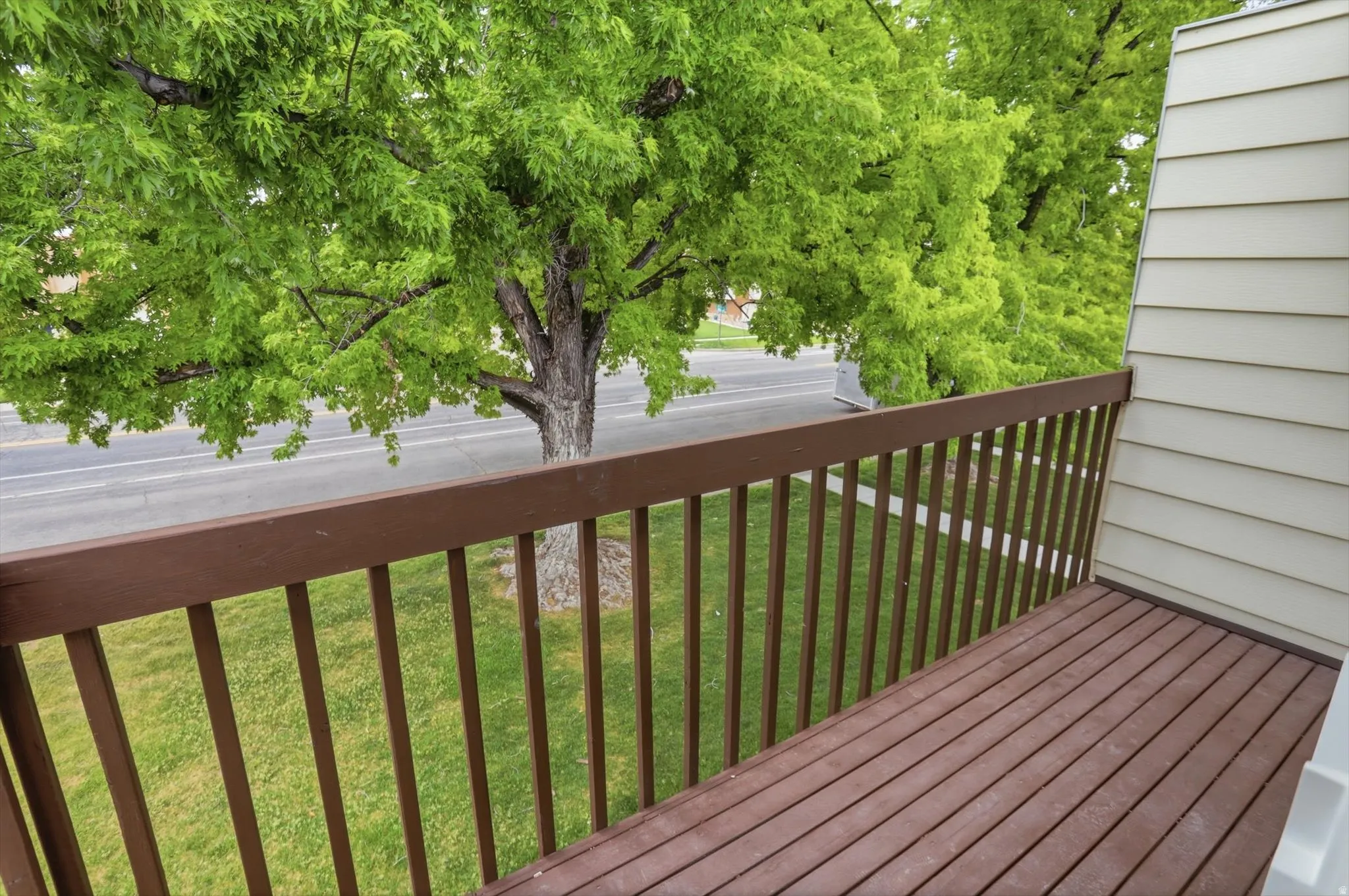 Private balcony featuring composite decking and a sturdy wood railing